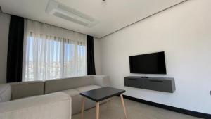 a living room with a couch and a flat screen tv at Bodrum has apart otel in Bodrum City