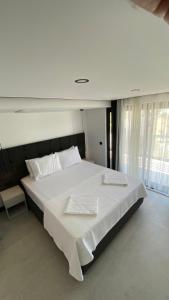 a large white bed with white sheets and pillows at Bodrum has apart otel in Bodrum City
