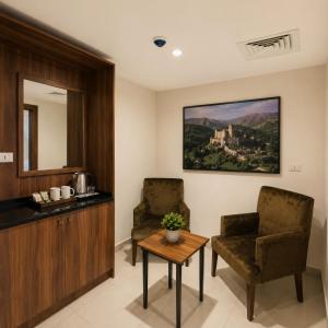 a living room with two chairs and a table at Ten Hills Hotel in Amman