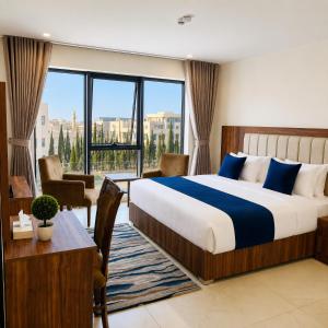 a hotel room with a bed and a desk and a window at Ten Hills Hotel in Amman +46 photos