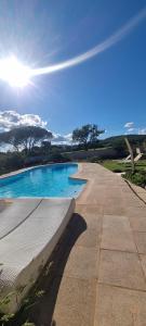 a swimming pool with the sun in the sky at Le Cocon des Vignes in Vidauban