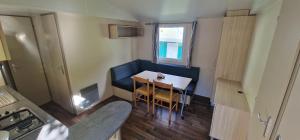 a small kitchen with a table and chairs in a room at Camping l'Or Bleu in Barrême