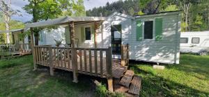 a green and white tiny house in a yard at Camping l'Or Bleu in Barrême