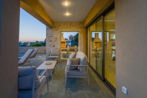 a room with chairs and a table and a balcony at Moon and Sun in Vamos