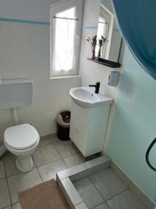 a white bathroom with a toilet and a sink at Sale&Pepe in Faraoaní