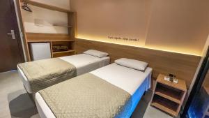 two beds in a small room with at Hotel & Pousada Favareto - Praia dos Ingleses in Florianópolis +28 photos