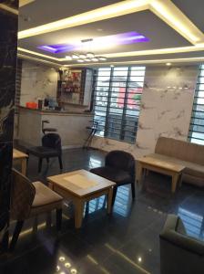 a waiting room with tables and chairs and a couch at Hazie Hotel in Lagos