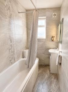a white bathroom with a tub and a sink at The Bromley's in Great Yarmouth +52 photos