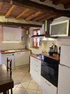 a kitchen with white cabinets and a black stove top oven at Il Vicolo in Buti