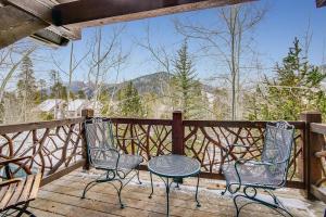 a patio with two chairs and a table on a deck at Cabin in the Pines 4 by SummitCove Lodging in Colorado in Keystone