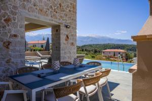 a patio with a table and chairs and a pool at Moon and Sun in Vamos