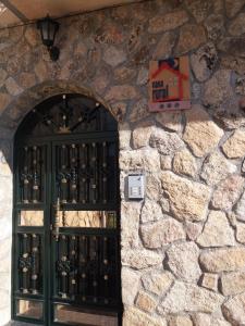 una pared de piedra con una puerta llena de botellas de vino en Casa Rural Amelia, en Cepeda