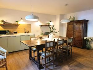 a kitchen and dining room with a wooden table and chairs at Iguzki Etxea in Urzainqui