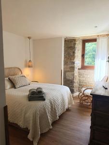 a bedroom with a bed and a stone wall at Iguzki Etxea in Urzainqui