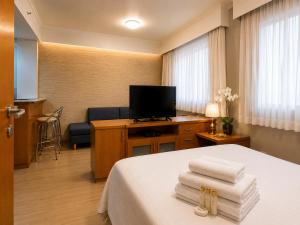 a hotel room with a bed and a flat screen tv at Lapidare Flat Hotel Comfor Alphaville até 4 pessoas in Barueri