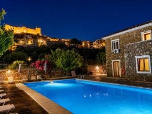a villa with a swimming pool in front of a building at PETRINO Hotel in Mythimna