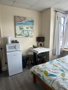 a room with a bed and a microwave and a table at Clarendon Lodge - accommodation only in Skegness