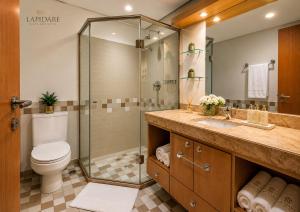 a bathroom with a shower and a toilet and a sink at Lapidare Flat Hotel Comfor Alphaville até 4 pessoas in Barueri