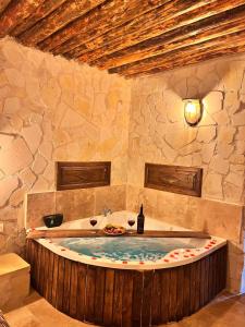 a bath tub in a stone room with a bottle of wine at MMF cave house in Nevşehir +141 photos