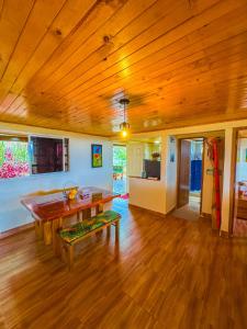 a living room with a wooden ceiling and a table at Alojamiento EL GITANO in Filandia