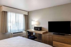a hotel room with a flat screen tv and a bed at Cape Cod Family Resort and Parks in West Yarmouth +27 photos