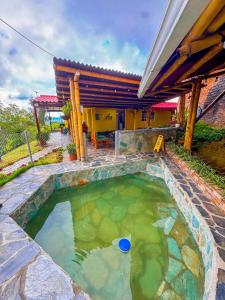 a large pool of water in front of a house at Alojamiento EL GITANO in Filandia