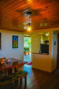 a living room with a table and a wooden ceiling at Alojamiento EL GITANO in Filandia