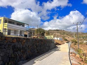 a house on a hill with a stone wall at EcoDream Lodge in Hermitage Island