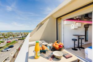 a balcony with a table with a bowl of fruit at Cap Cosy studio standing Naturiste Heliopolis Cap d'Agde with Sea View in Cap d'Agde
