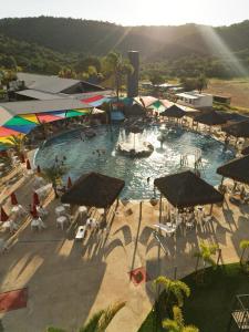 a large swimming pool with umbrellas and people in it at Chalés - Aquabeat in Sao Jose da Lapa