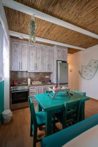 a kitchen with a green table and chairs at Kalypso Rental Apartment in Myloi