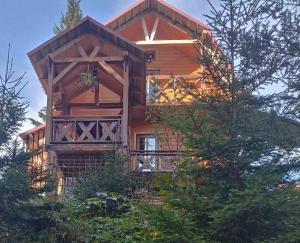 a log cabin with a balcony in the trees at Горянка in Guta