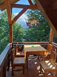 a porch with a table and chairs and a chandelier at Горянка in Guta