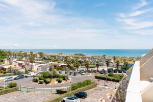a view of a parking lot with the ocean in the background at Cap Cosy studio standing Naturiste Heliopolis Cap d'Agde with Sea View in Cap d'Agde