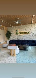 a living room with a blue couch and a stone wall at Green side in Kvariati
