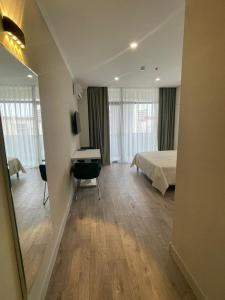 a bedroom with a bed and a desk in a room at Green side in Kvariati