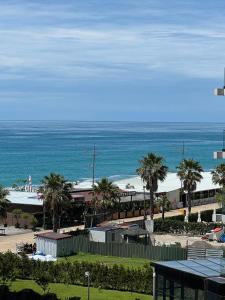 a view of a beach with palm trees and the ocean at Green side in Kvariati