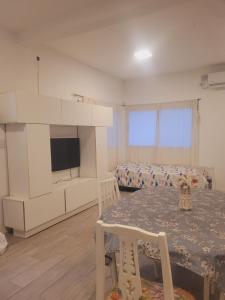 a living room with a table and a tv in a room at Casa quinta con gran parque, pileta y parrilla a 15 min del aeropuerto in La Unión