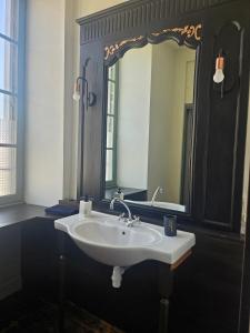 a bathroom with a sink and a large mirror at Private Apartment in Rochechouart +30 photos