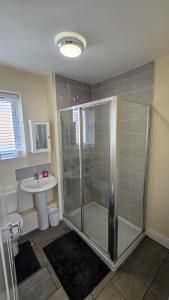 a bathroom with a shower and a sink at Spacious and Modern 4BR with Hot Tub and Garden in Peterborough +52 photos