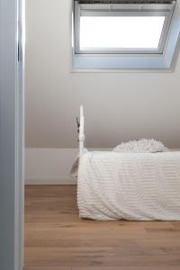 a bed in a room with a window at Stientjeshof "Het Paardenhuisje & Hooihuys " in Sint-Lievens-Houtem
