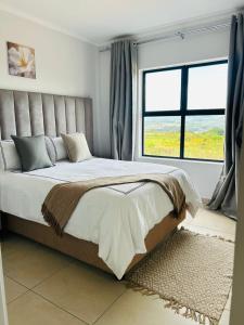 a bedroom with a large bed with a large window at Elusive Haven in Nelspruit +120 photos