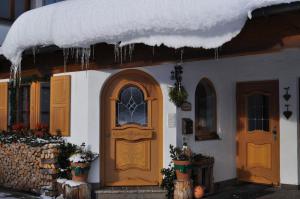 a house with snow on the roof and a door at Gästehäuser Schwemmbauer in Reit im Winkl +93 photos