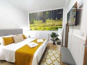 a bedroom with a bed and a painting on the wall at Casa dos Passos 1 in Guarda