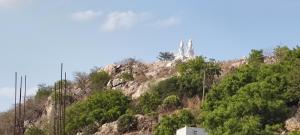 a rocky hill with a monument on top of it at Hotel Jyothi Kumar Royal ac rooms in Srikalahasti +35 photos