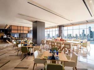 a restaurant with tables and chairs and a view of the city at Hotel Grand Tela Suite Delhi in Gurgaon