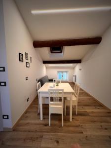 a dining room with a white table and chairs at B&Bee alla corte in Dossobuono +16 photos
