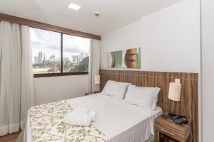 a bedroom with a large bed with a window at Nobile Hotel em Brasília 97172 in Brasília