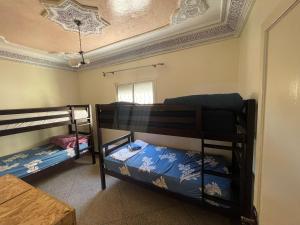 two bunk beds in a room with a ceiling at Mavi Surf Stay Tamraght in Tamraght Ouzdar