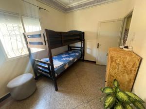 a bedroom with two bunk beds and a window at Mavi Surf Stay Tamraght in Tamraght Ouzdar